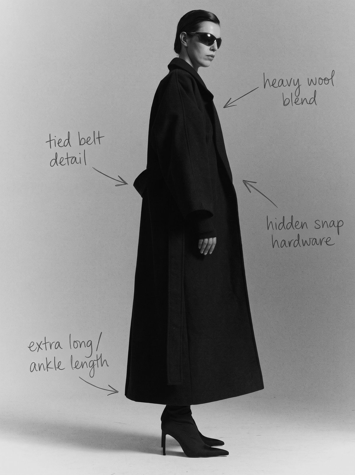 Ankle-length black wool coat with tied belt and hidden snap fastening, with handwritten design notes